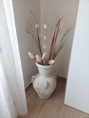 a white vase with some plants in a room at Casa Darla in Cesano Boscone