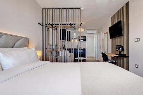 a bedroom with a white bed and a dining room at Palm Suites in Estepona