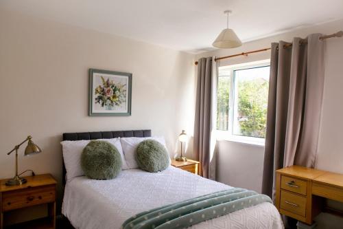 a bedroom with a bed with two pillows and a window at 70 Abbotsbury Road, Bury St Edmunds, IP33 2HP in Moffat