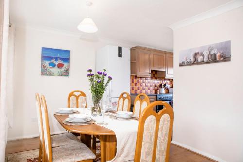 a dining room with a table and chairs and a kitchen at 70 Abbotsbury Road, Bury St Edmunds, IP33 2HP in Moffat