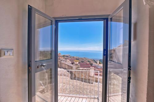 a door to a balcony with a view of the ocean at Al Torrione 1 in Monte SantʼAngelo