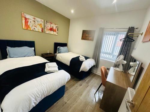 a hotel room with two beds and a window at Burton Urban Apartment in Burton upon Trent