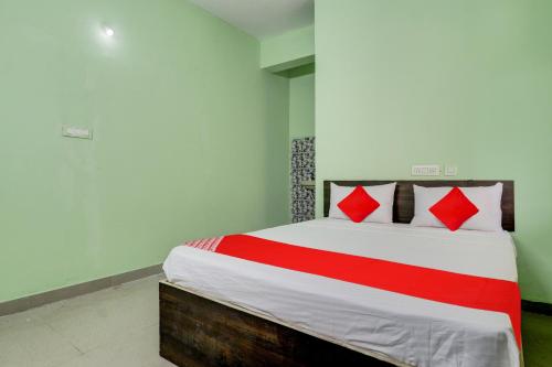 a bedroom with a large bed with red pillows at Hotel Sunshine in Hyderabad