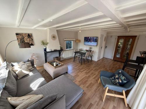a living room with a couch and a table at Boshuis Bubbels Wellness Chalet with Private HOTTUB and SAUNA - Super Holiday House with Huge Garden and Private Parking Space - Veluwe Holiday Voorthuizen in Voorthuizen
