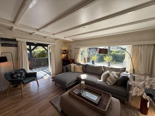 a living room with a couch and a table at Boshuis Bubbels Wellness Chalet with Private HOTTUB and SAUNA - Super Holiday House with Huge Garden and Private Parking Space - Veluwe Holiday Voorthuizen in Voorthuizen