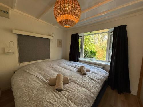 a bedroom with a bed with two towels on it at Boshuis Bubbels Wellness Chalet with Private HOTTUB and SAUNA - Super Holiday House with Huge Garden and Private Parking Space - Veluwe Holiday Voorthuizen in Voorthuizen