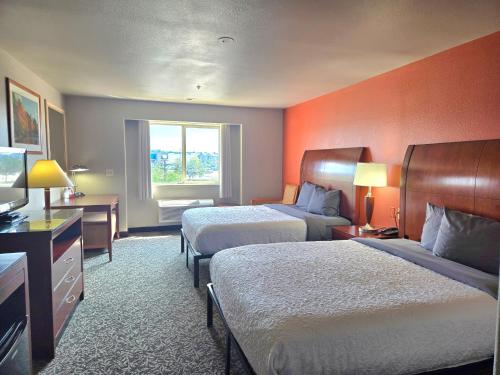a hotel room with two beds and a television at Olympia Inn in Colorado Springs