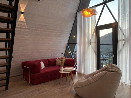 a living room with a red couch and a table at Space Trip Hotel in Artavaz