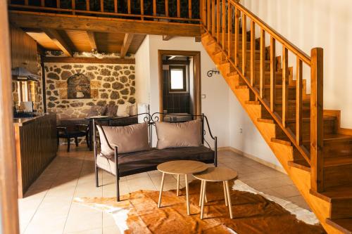 a living room with a staircase and a couch and a table at Filiantra Suites in Kato Trikala Korinthias