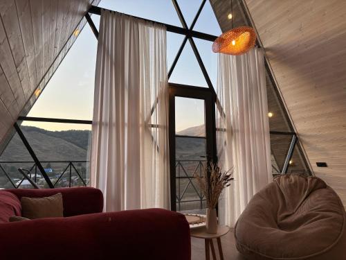 a living room with a couch and a large window at Space Trip Hotel in Artavaz