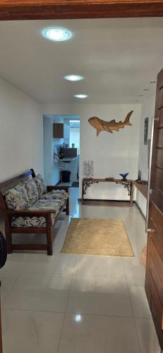 a living room with two beds and a dolphin on the wall at Flat - Studio - Casas Arraial Só Lazer in Arraial do Cabo