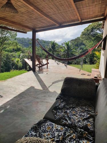 a porch with a hammock and a view of a park at Casa Arco-Iris in Itacaré