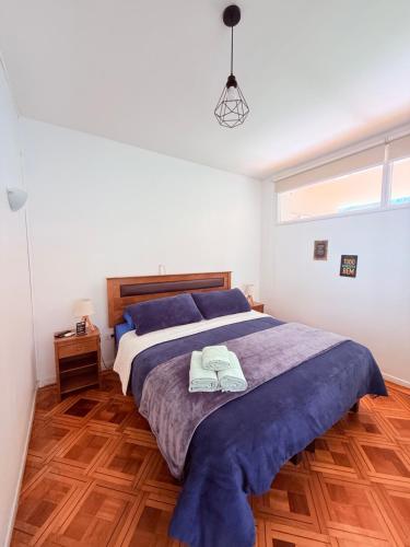 a bedroom with a large bed with two towels on it at MAKTVB Europa - Hostal Boutique in Santiago