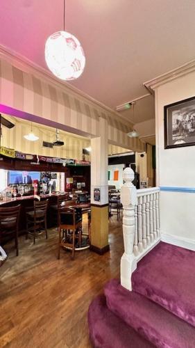 a living room with a purple couch and a restaurant at Shanahans B&B with Sports Bar in Birmingham