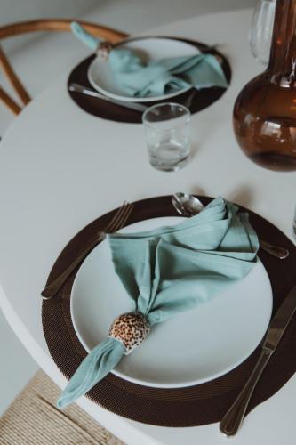 a white plate with a green bow on a table at Searenity Villas in Rivière Noire