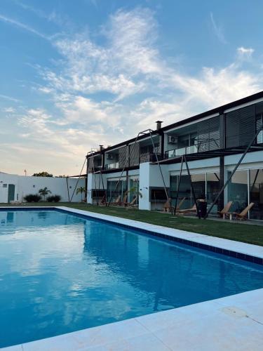 ein Haus mit einem Swimmingpool vor einem Gebäude in der Unterkunft Villa Toscana in Yaguarón