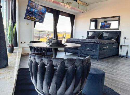 a room with a couch and a table and a bed at Deluxe Penthouse Suite zentral mit Goldstadtblick in Pforzheim