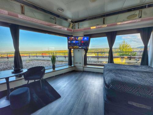 a train room with a bed and a desk and windows at Deluxe Penthouse Suite zentral mit Goldstadtblick in Pforzheim