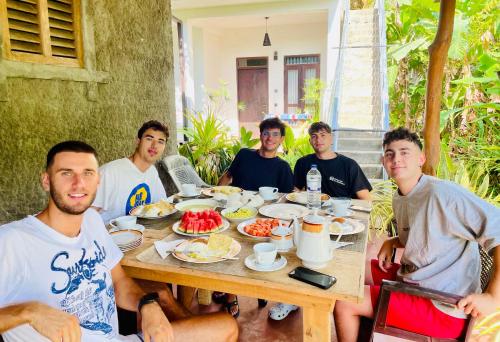 a group of men sitting around a table eating food at Dimuthu Green Villa in Sigiriya