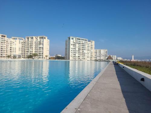 ein großer Wasserkörper mit Gebäuden im Hintergrund in der Unterkunft Departamento Laguna del Mar in La Serena