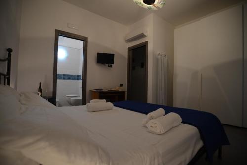a bedroom with a white bed with towels on it at Ce Tour - Cetara Guest House in Cetara
