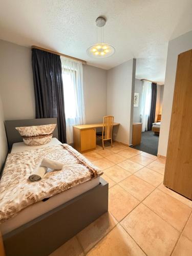 a bedroom with a bed and a desk in a room at Sparta Hotel in Pottenstein