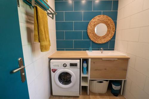 a small bathroom with a washing machine and a sink at Kaza Maléssa in Sainte-Marie