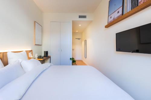 a bedroom with a bed and a flat screen tv at The Babel Community - République - Joliette in Marseille