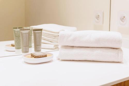 a pile of towels on a counter in a bathroom at The Babel Community - République - Joliette in Marseille