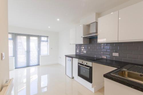 a kitchen with white cabinets and a black counter top at Radstock Road - Room 1 in Southampton