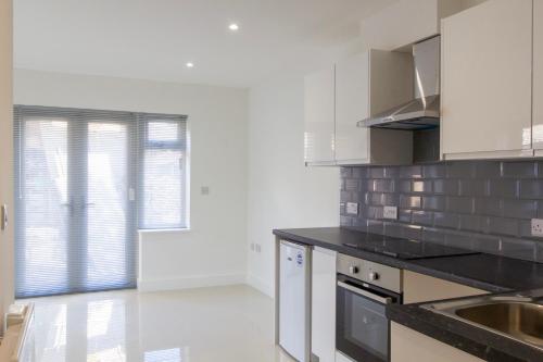 a kitchen with white cabinets and black counter tops at Radstock Road - Room 1 in Southampton