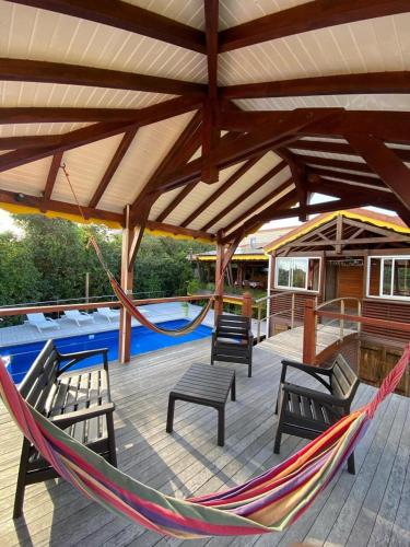 a patio with a hammock and a pool at Villa Atypique - Charme & Confort in Le Moule