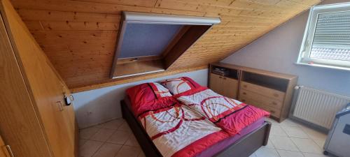 a small bed in a small room with a wooden ceiling at HomeStay Sandra in Hockenheim