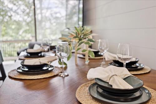 a dining room table with black plates and wine glasses at Smoky Shores Lakeview Cabin By Beyond Expectations in Sandy Ridge