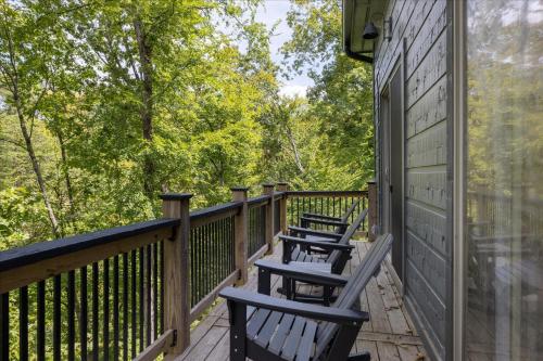 three chairs on a deck with trees in the background at Smoky Shores Lakeview Cabin By Beyond Expectations in Sandy Ridge