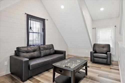 a living room with a leather couch and a table at Smoky Shores Lakeview Cabin By Beyond Expectations in Sandy Ridge