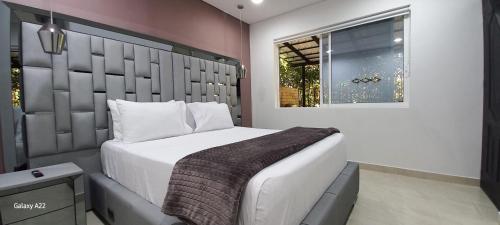 a bedroom with a large bed and a window at Hotel y Cabañas Parinzzi in Guatapé