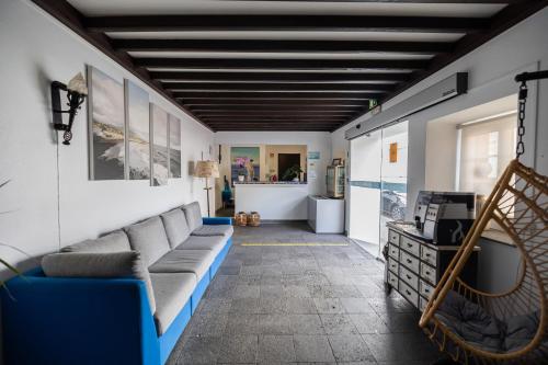 a living room with a couch and a tv at Aparthotel Barracuda in Ponta Delgada