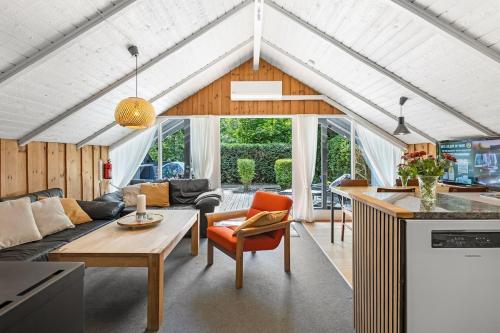 a kitchen and living room in a house at Unique forest cabin by lake near Legoland, ForestCabinDK in Ansager