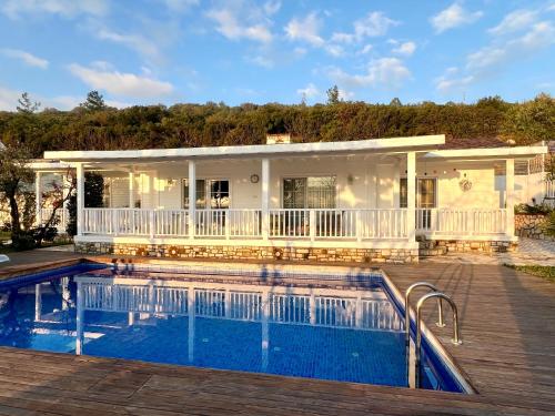 a house with a swimming pool in front of it at Casa del Olivia in Seferihisar