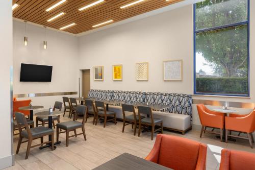 a restaurant with tables and chairs and a flat screen tv at Holiday Inn Express Vancouver Airport-Richmond by IHG in Richmond