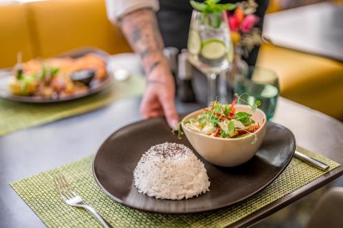 a plate of rice and a bowl of food on a table at Novotel München City in Munich