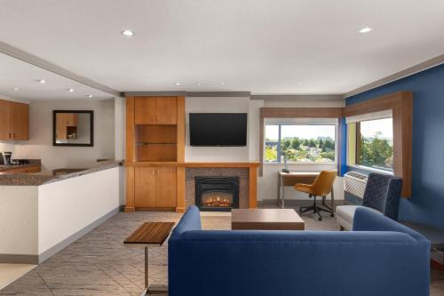 a living room with a blue couch and a fireplace at Holiday Inn Express Vancouver Airport-Richmond by IHG in Richmond