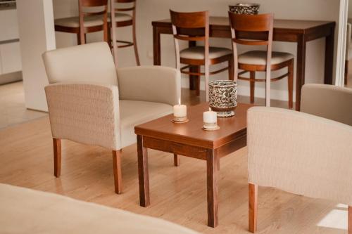 a living room with chairs and a table with candles at Hotel Carat Apart Boutique in Rosario