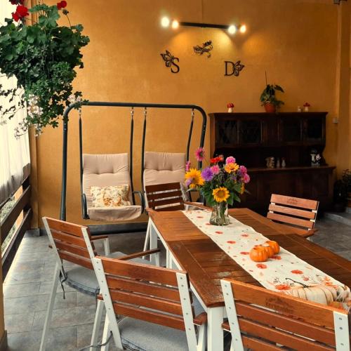 a dining room with a table and chairs and flowers at Pensiunea Sorina Deea in Bicazu Ardelean