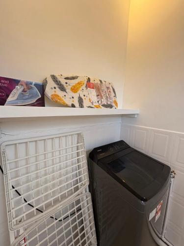 a laundry room with a shelf and a trash can at Searenity Villas in Rivière Noire
