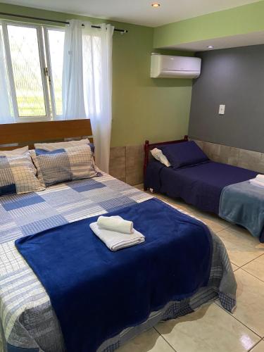 a bedroom with two beds with towels on them at Espaço dos Lobato in Miguel Pereira