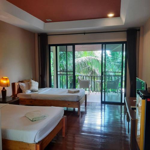 a hotel room with two beds and a balcony at The Leaf Pool Villa Resort in Muak Lek District