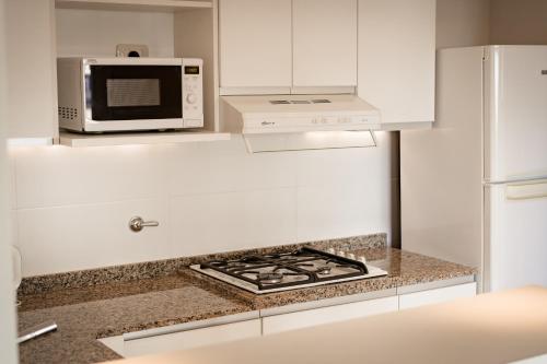 a kitchen with a microwave and a stove top oven at Hotel Carat Apart Boutique in Rosario