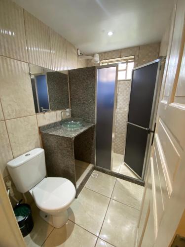 a small bathroom with a toilet and a shower at Espaço dos Lobato in Miguel Pereira